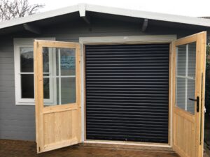 Black roller shutter door installed in outbuilding