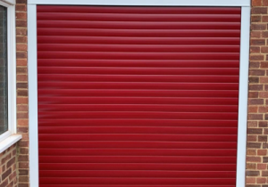 Small electric roller shutter garage door in a red colour